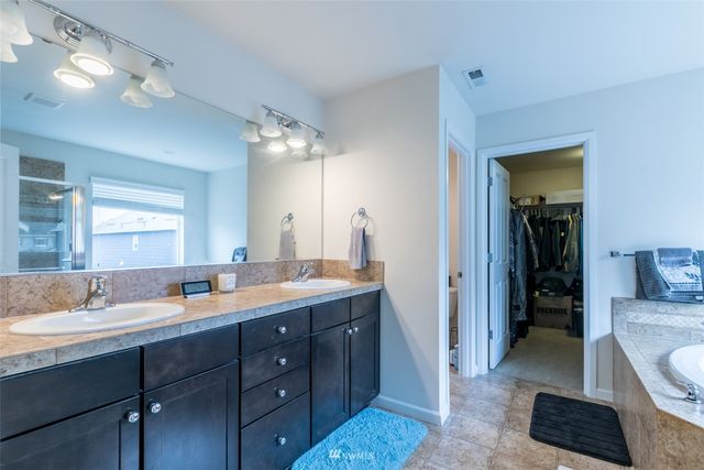 a en suite bathroom with a granite countertop sink mirror and toilet