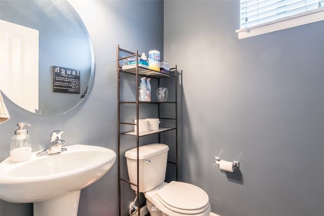 a bathroom with a sink a toilet and mirror