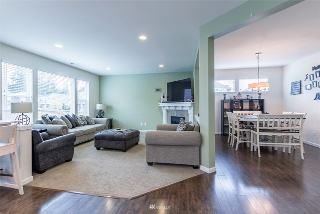 a living room with furniture wooden floor and a large window