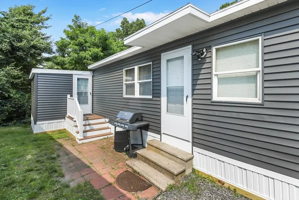 a view of a house with a small deck and a yard floor