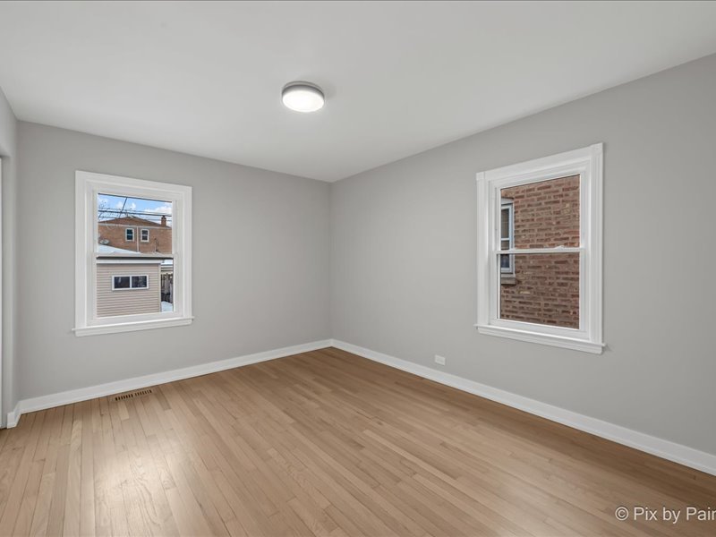 3922 West 59th Place Chicago, IL 60629 - Photo 16 of 29 a view of an empty room with wooden floor and a window