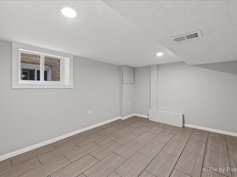 3922 West 59th Place Chicago, IL 60629 - Photo 22 of 29 a view of an empty room with wooden floor and a window