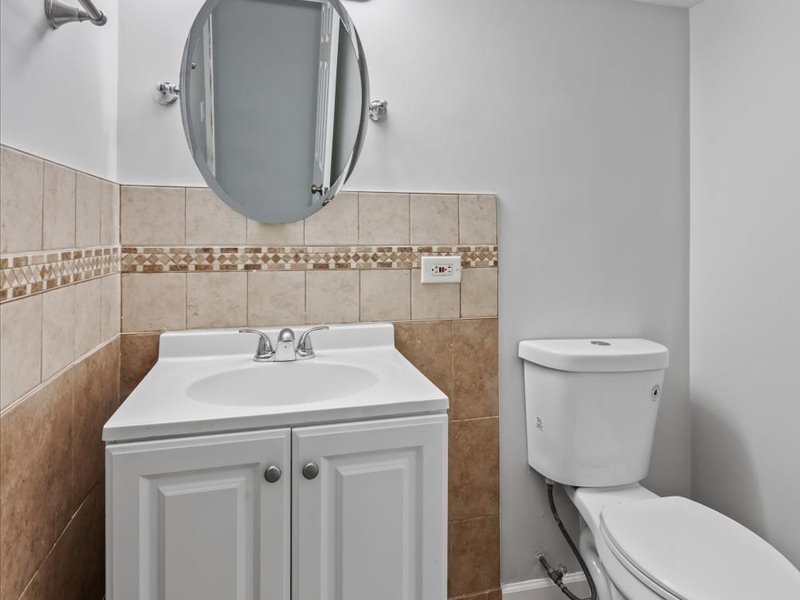 3922 West 59th Place Chicago, IL 60629 - Photo 23 of 29 a bathroom with a toilet a sink and a mirror