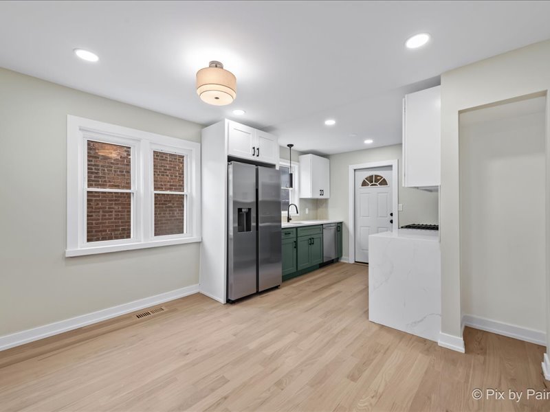 3922 West 59th Place Chicago, IL 60629 - Photo 6 of 29 a kitchen with stainless steel appliances granite countertop a refrigerator a sink a stove and white cabinets with wooden floor
