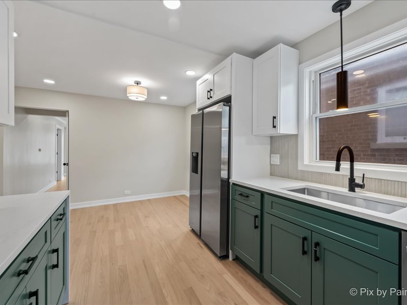 3922 West 59th Place Chicago, IL 60629 - Photo 9 of 29 a kitchen with stainless steel appliances granite countertop a sink and dishwasher refrigerator a microwave oven with wooden floor