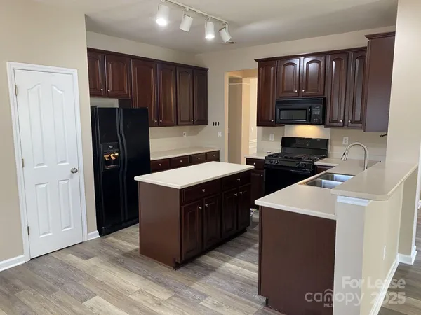 a kitchen with stainless steel appliances granite countertop wooden cabinets a refrigerator and a stove