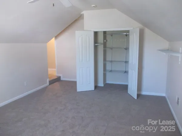 an empty room with closet and windows