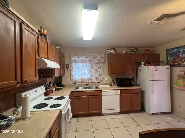 a kitchen with a sink a stove top oven and cabinets