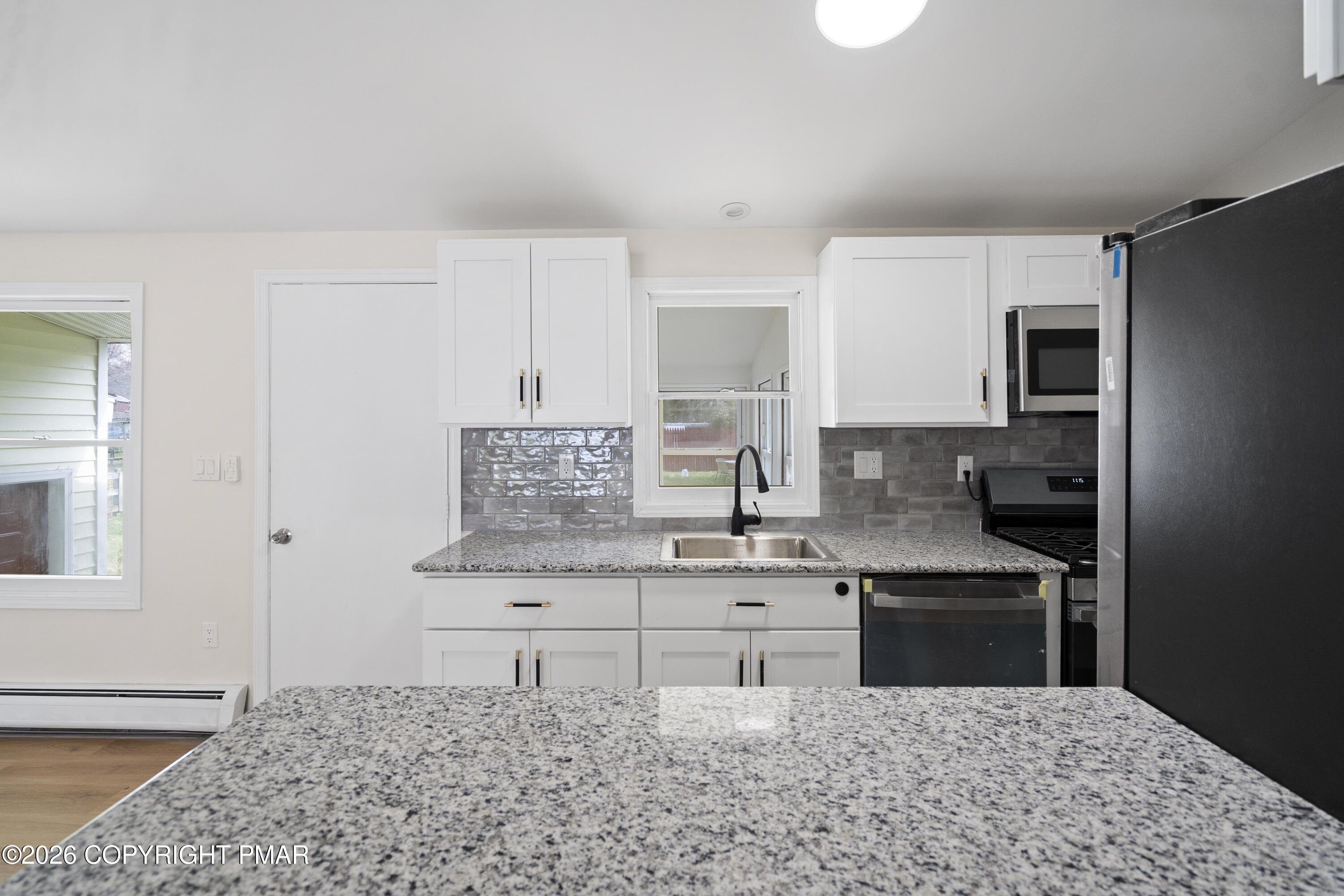 605 5th Street Matamoras, PA 18336 - Photo 6 of 27 a kitchen with stainless steel appliances kitchen island granite countertop a stove a sink and a refrigerator