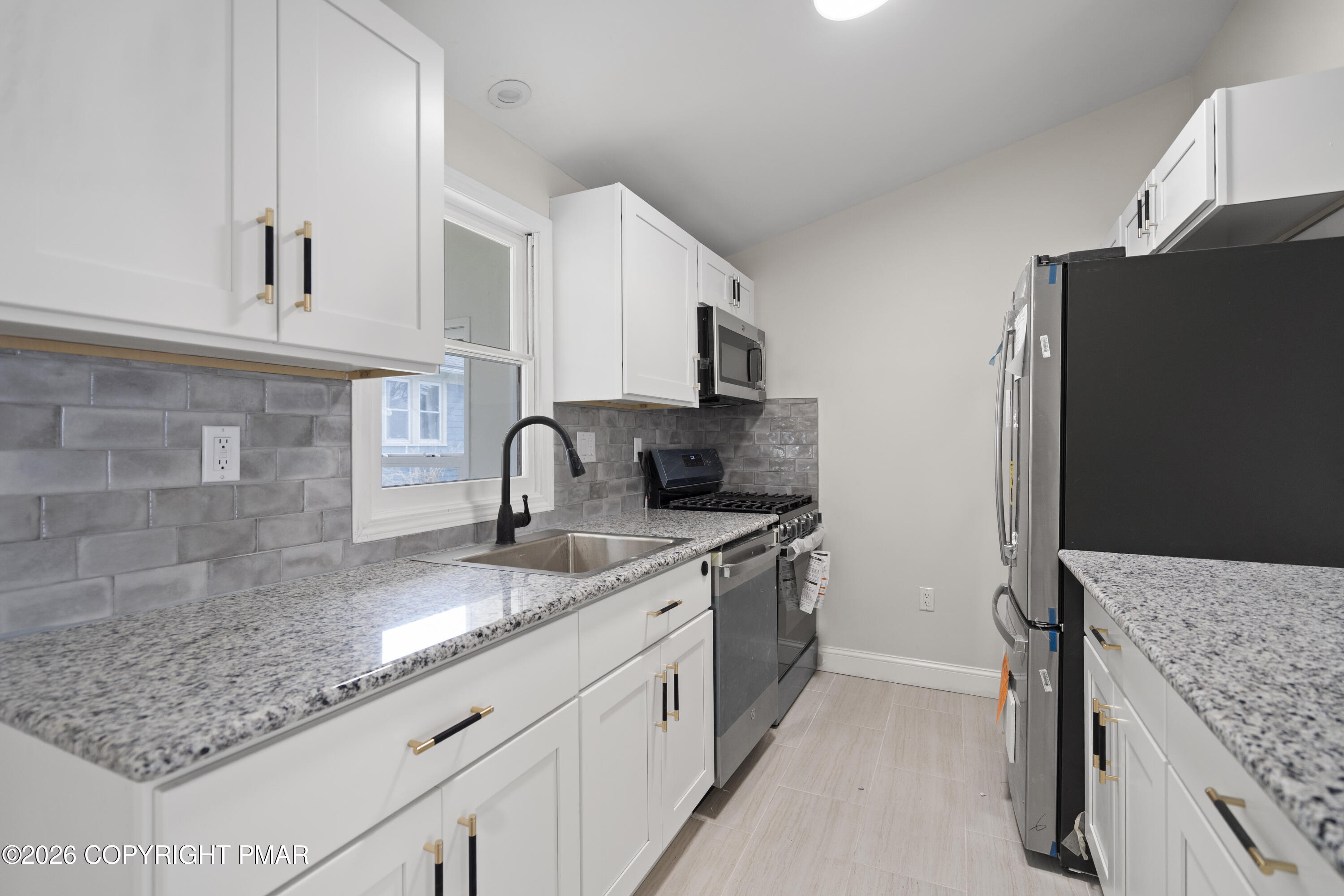 605 5th Street Matamoras, PA 18336 - Photo 8 of 27 a kitchen with stainless steel appliances granite countertop a sink stove and refrigerator