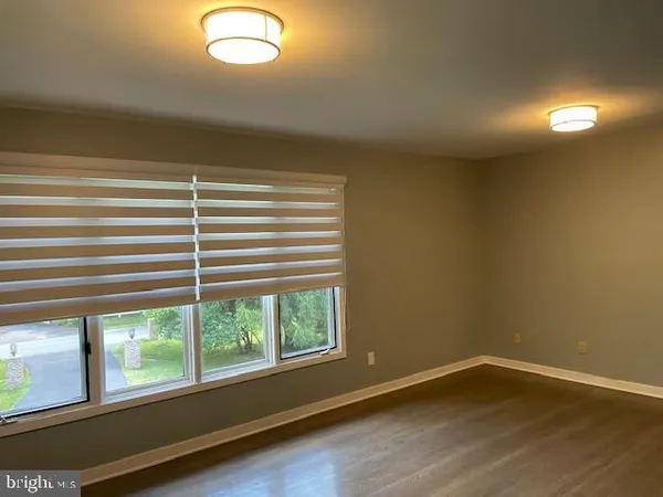an empty room with wooden floor and closet