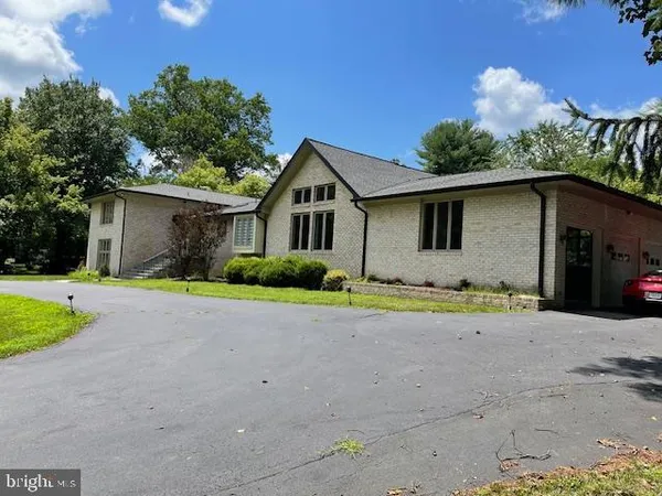 a front view of house with yard and trees in the background