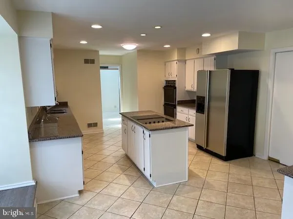 a kitchen with stainless steel appliances granite countertop a refrigerator and a stove