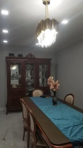 a view of a dining room with furniture a chandelier and window