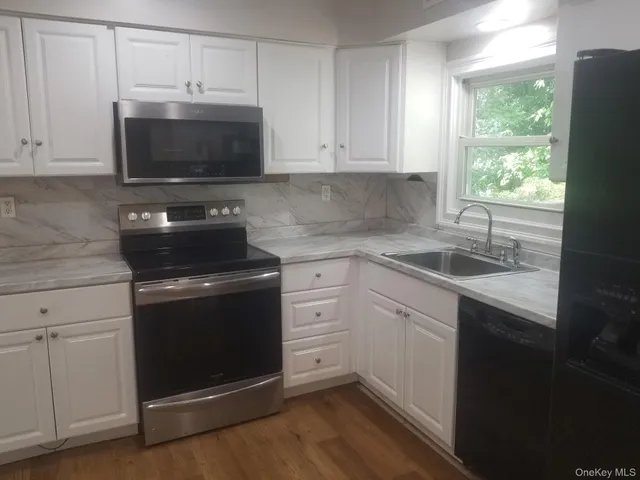 a kitchen with stainless steel appliances a stove microwave and sink