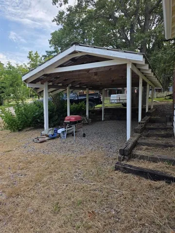 a view of backyard with table and chairs under an umbrella