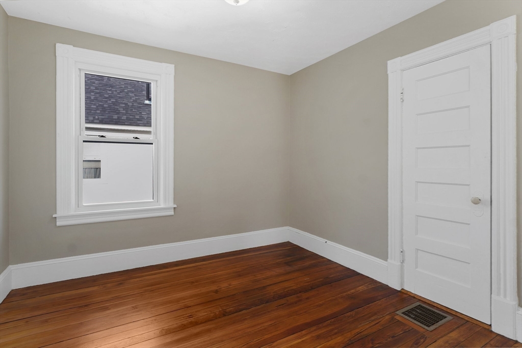 86-88 Chestnut Street Springfield, MA 01151 - Photo 16 of 40 a view of an empty room with wooden floor and a window