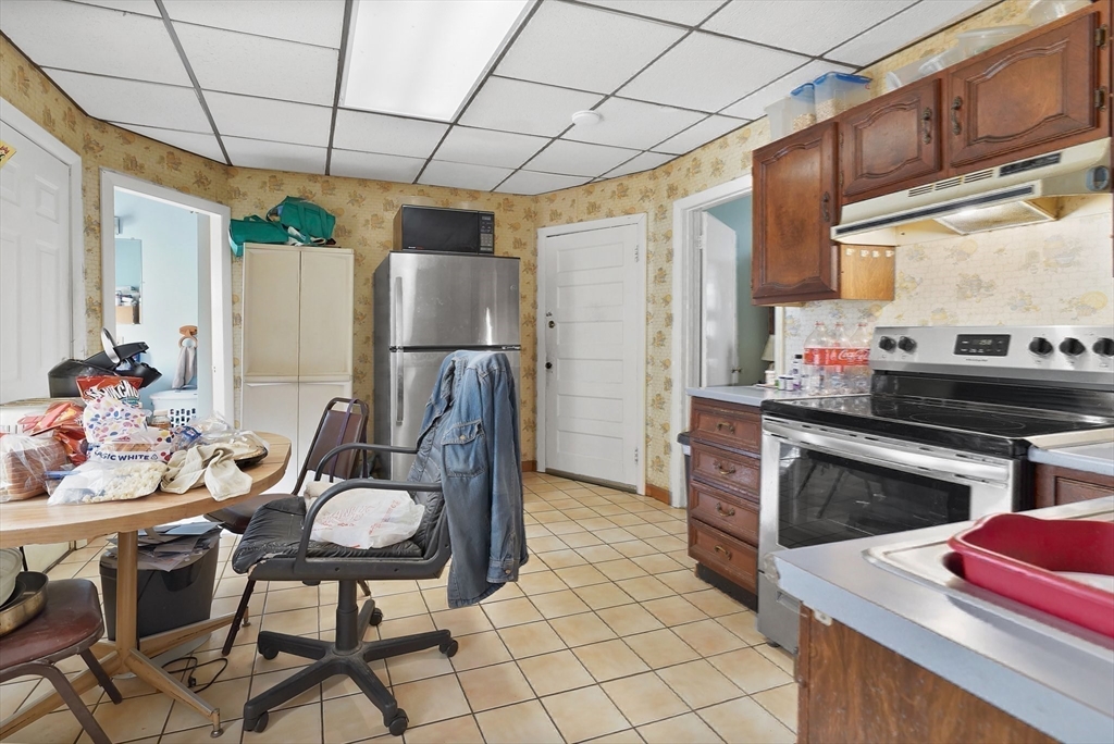 86-88 Chestnut Street Springfield, MA 01151 - Photo 24 of 40 a kitchen with stainless steel appliances kitchen island granite countertop a table chairs in it and wooden floors