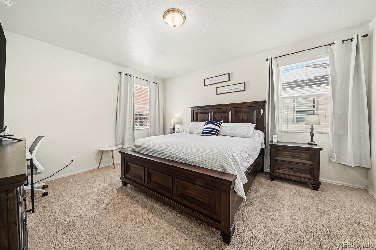 910 Pierson Court Windsor, CO 80550 - Photo 15 of 42 a bedroom with a bed and a table