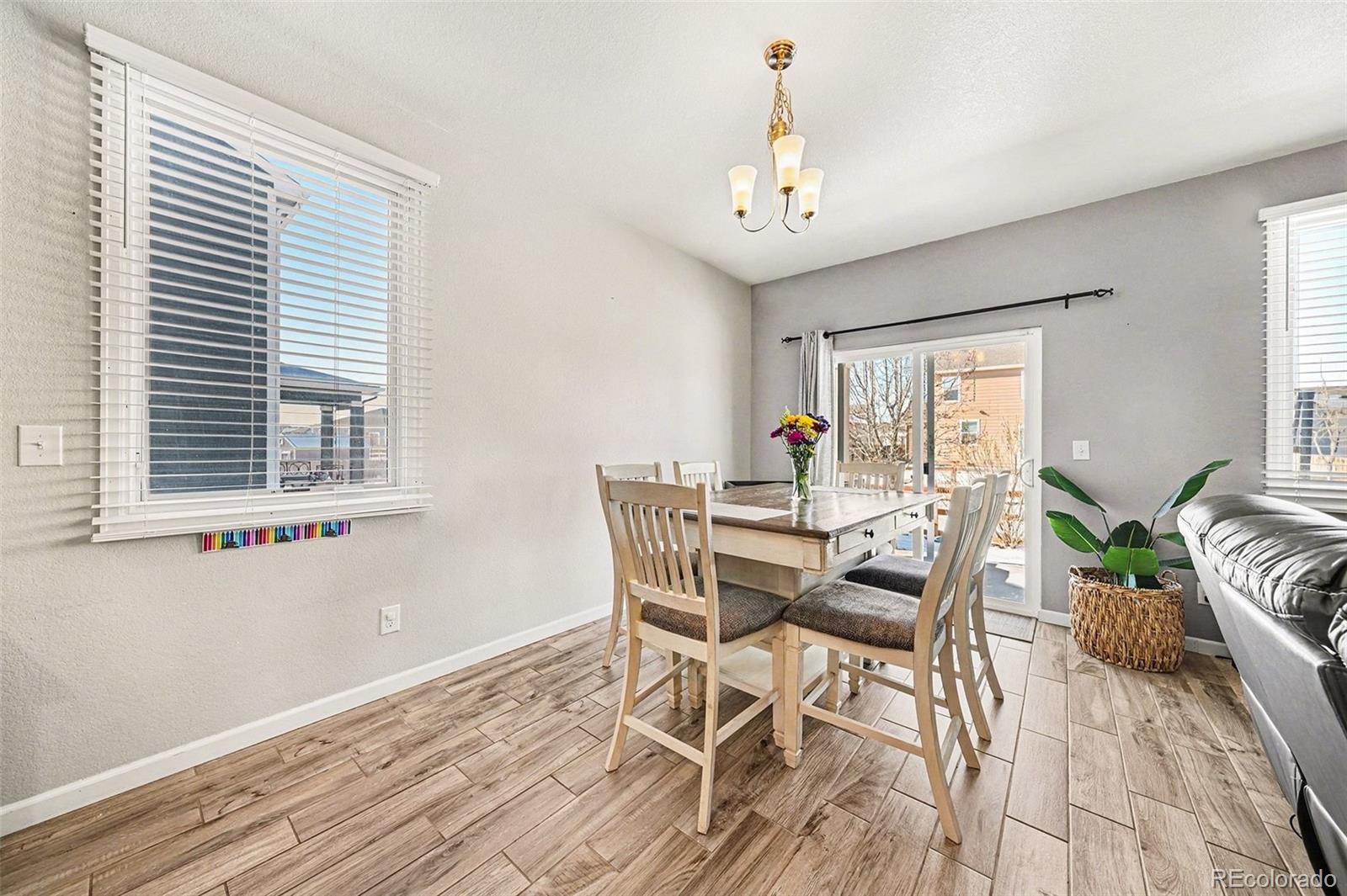 910 Pierson Court Windsor, CO 80550 - Photo 9 of 42 a view of a dining room with furniture window and wooden floor