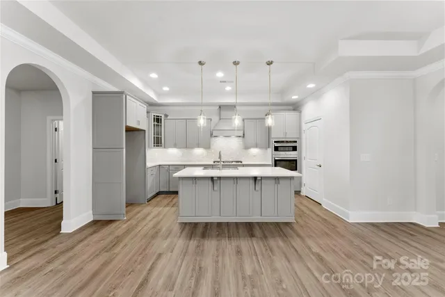 a kitchen with kitchen island white cabinets and stainless steel appliances