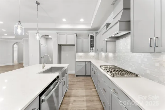 a kitchen with granite countertop a sink stove and cabinets