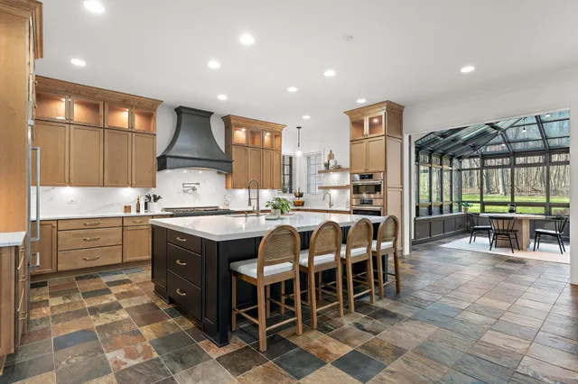 a spacious bedroom with a large bed a flat tv screen and dresser