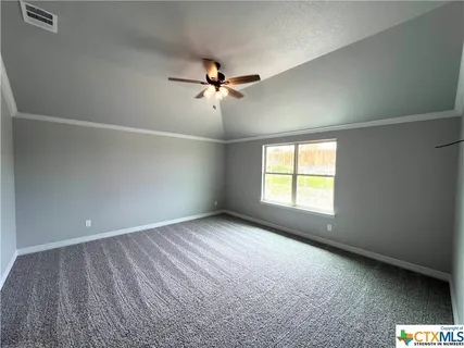 an empty room with a window and a ceiling fan