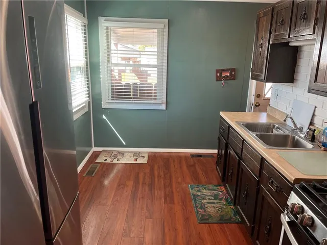 a view of a kitchen with wooden floor and a sink