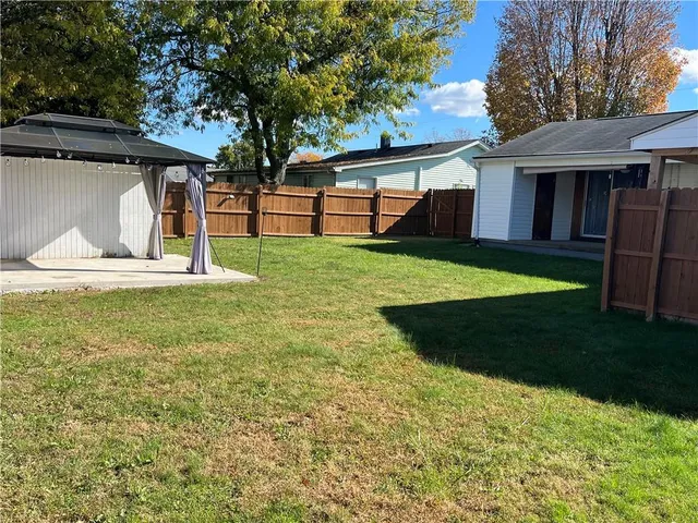 a view of a house with backyard and sitting area
