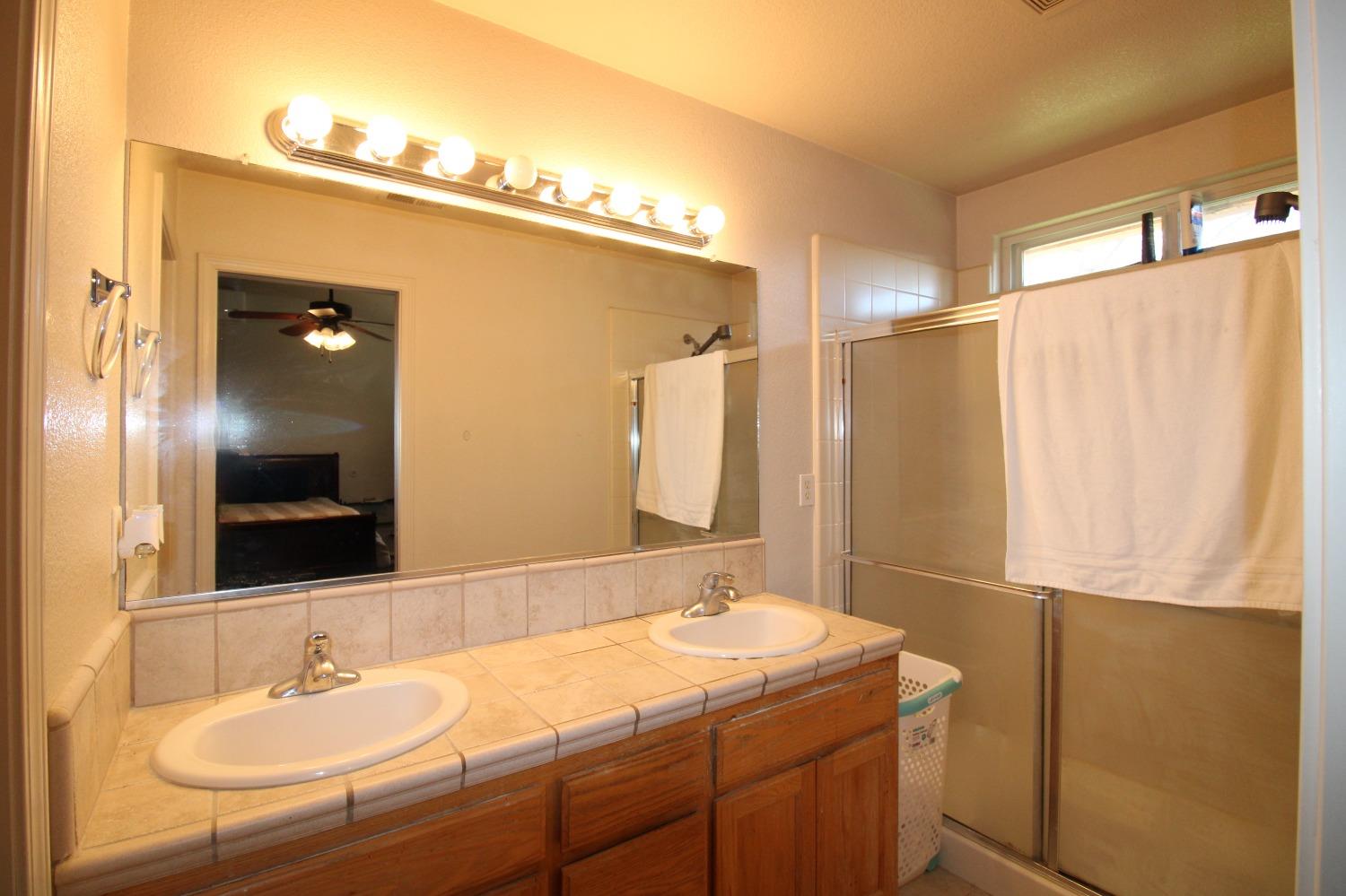 554 St Michelle Drive Madera, CA 93637 - Photo 17 of 19 a bathroom with a sink vanity and a mirror