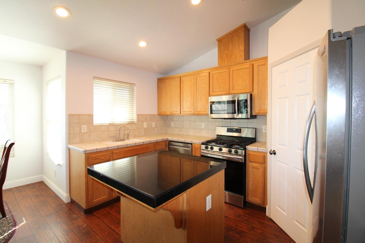 554 St Michelle Drive Madera, CA 93637 - Photo 6 of 19 a kitchen with kitchen island a counter space a sink and stainless steel appliances