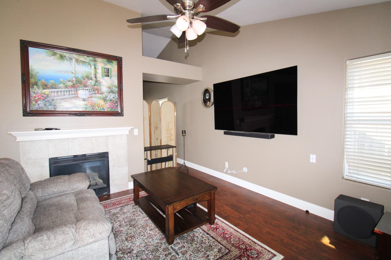 554 St Michelle Drive Madera, CA 93637 - Photo 9 of 19 a living room with furniture a flat screen tv and a fireplace