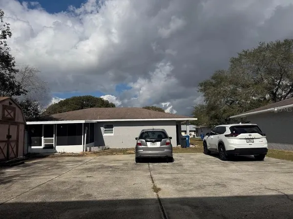 a front view of a house with cars parked