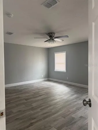 wooden floor in an empty room with a window