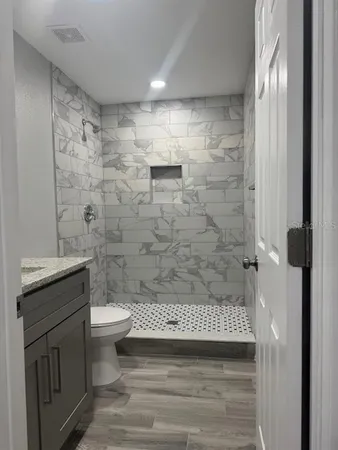 a bathroom with a shower toilet and sink