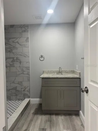 a bathroom with a granite countertop sink a toilet and shower