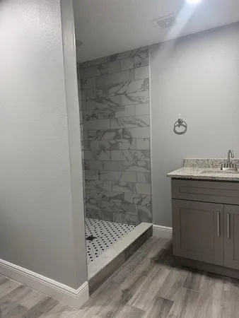 a bathroom with a sink a toilet and shower