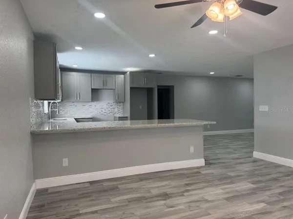 a view of kitchen with granite countertop cabinets and wooden floor