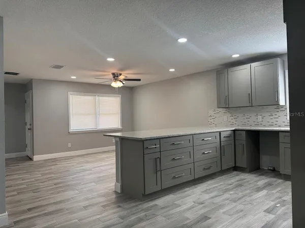 a spacious bathroom with a granite countertop sink and a mirror