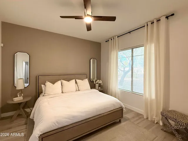 a bedroom with a large bed and a chandelier