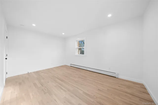 an empty room with a wooden floor and windows