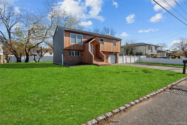 a view of a house with a big yard and large trees