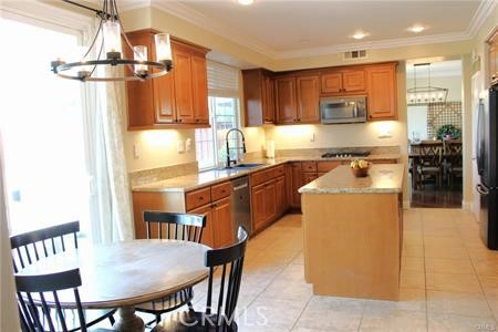 45344 St Tisbury Street Temecula, CA 92592 - Photo 7 of 28 a kitchen with a table chairs refrigerator and microwave