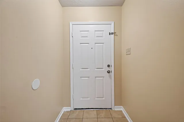 an empty room with windows and ceiling fan