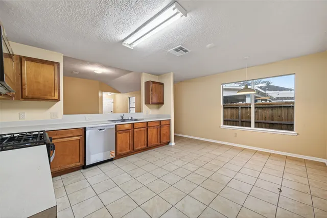 a large kitchen with a stove top oven a sink a microwave and cabinets