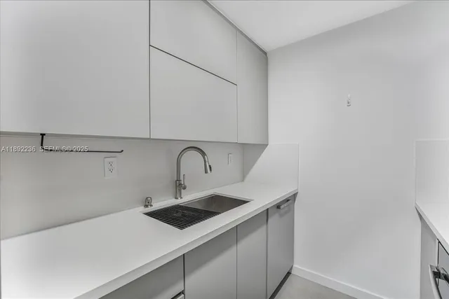 a kitchen with a sink cabinets and white countertops