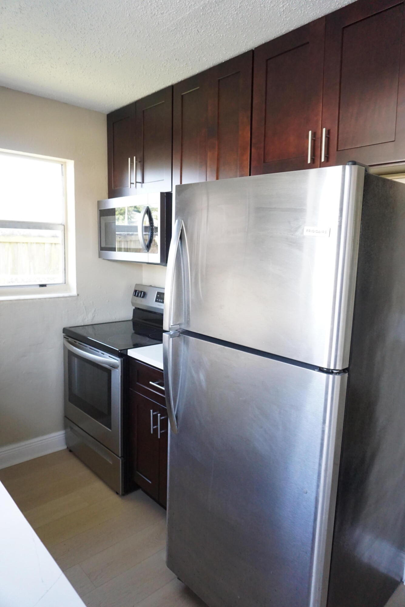 1601 West 37th Street, Unit 6 Riviera Beach, FL 33404 - Photo 2 of 12 a white refrigerator freezer and a stove sitting inside of a kitchen