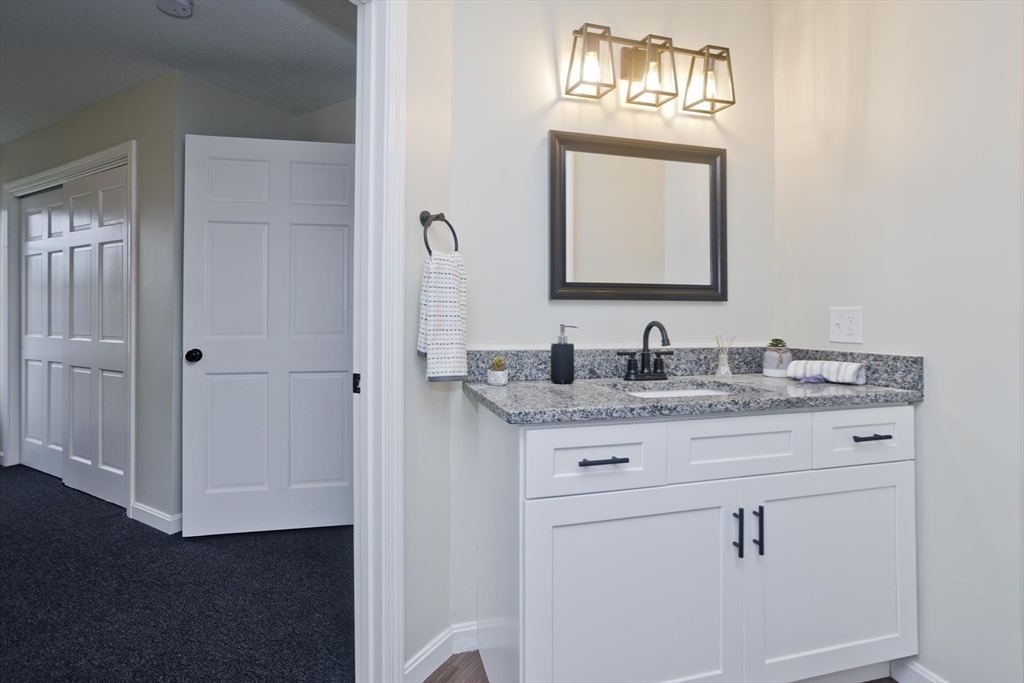 2089 Oak Street Three Rivers, MA 01080 - Photo 26 of 42 a bathroom with a granite countertop sink a mirror and a vanity