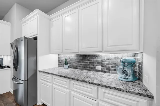 a kitchen with stainless steel appliances granite countertop a sink refrigerator and microwave